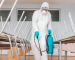 40aff4d5-man-sterile-uniform-with-gloves-mask-holding-sprayer-spraying-with-disinfectant-floor-classroom-1.png